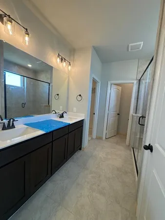 a bathroom with a double vanity sink mirror double and shower