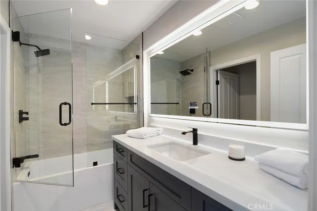 a bathroom with a tub sink mirror and shower