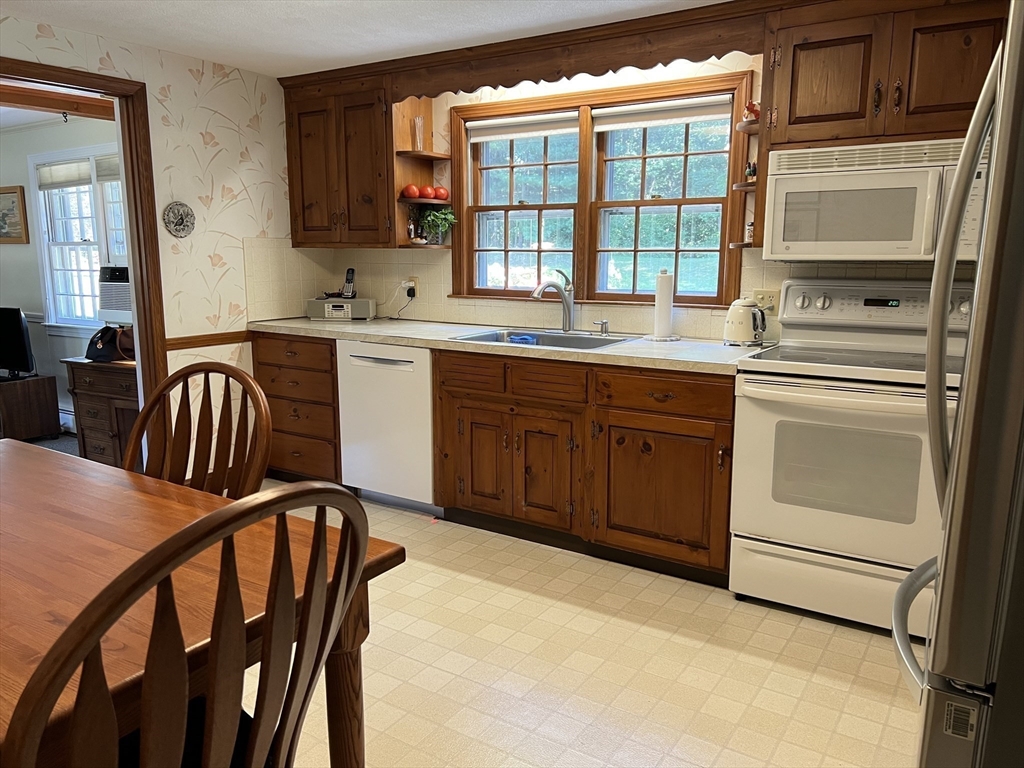 71 Greenbrook Road Hamilton, MA 01982 - Photo 13 of 33 a kitchen with a table chairs stove and cabinets