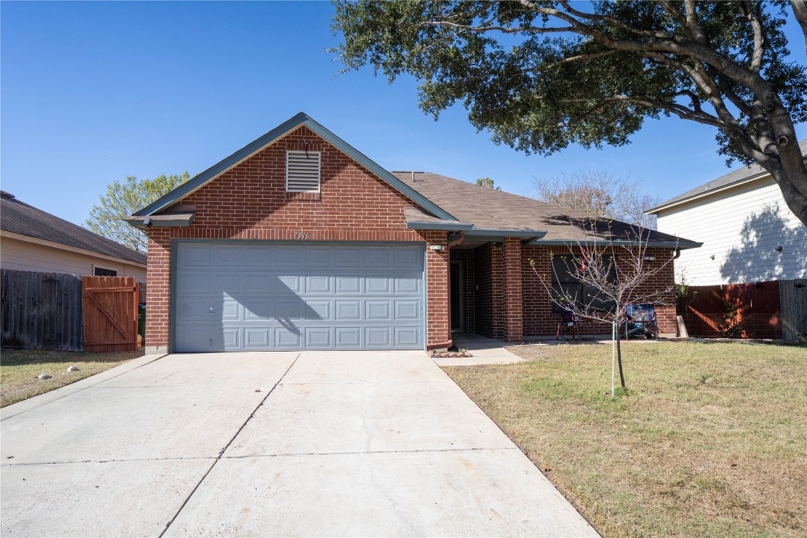 Single story home with brick siding, concrete driveway, and an attached garage