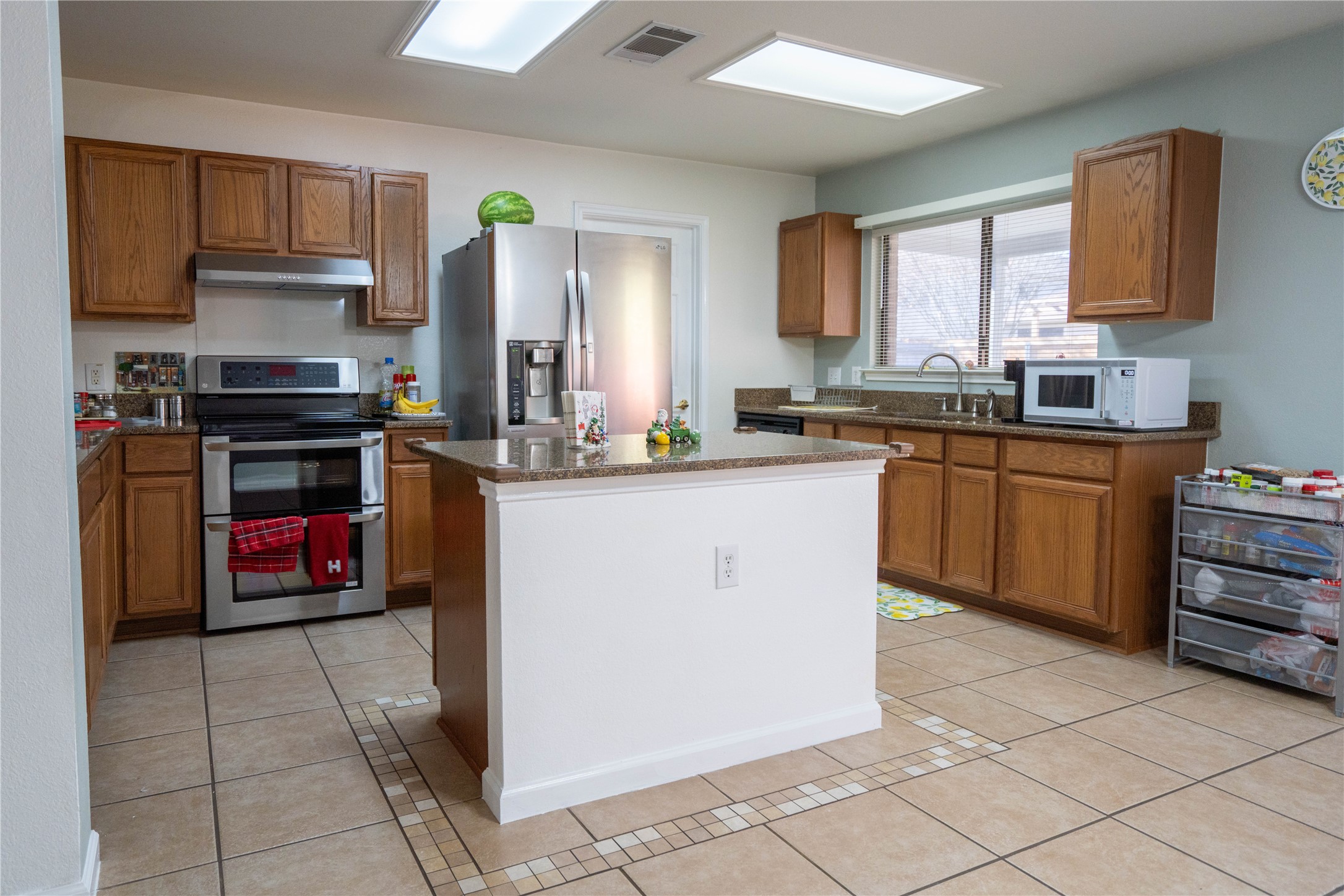 7516 Cats-Eye Lane Austin, TX 78747 - Photo 11 of 30 a kitchen with stainless steel appliances granite countertop a stove sink and cabinets