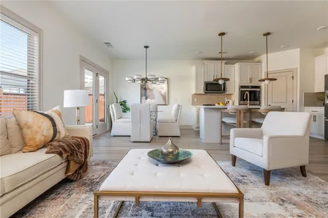 a living room with furniture a refrigerator and kitchen view