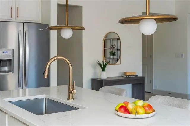 a kitchen with stainless steel appliances granite countertop a sink a refrigerator and a stove