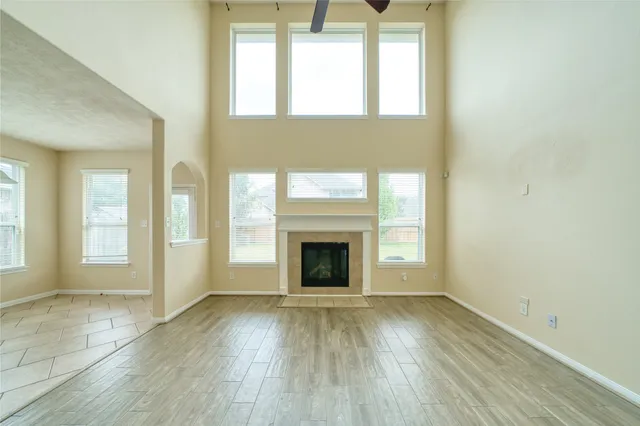 a view of a livingroom with wooden floor a fireplace and windows