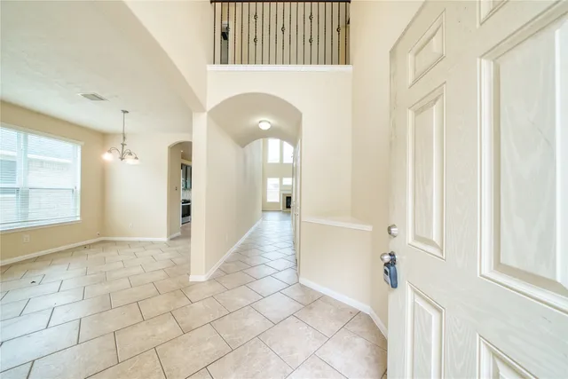 a view of a hallway with wooden floor and a bathroom