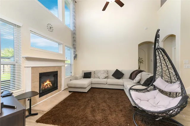 an empty room with wooden floor fireplace and windows