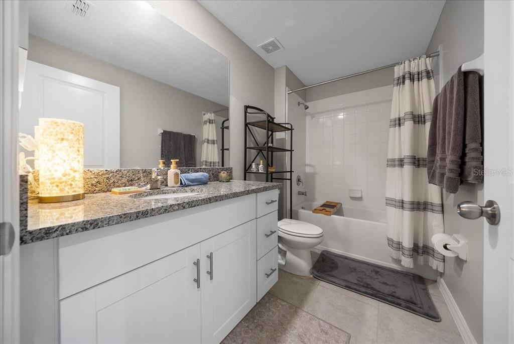9329 Southwest 57th Terrace Ocala, FL 34476 - Photo 38 of 64 a bathroom with a granite countertop sink toilet and shower