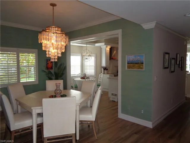 a dining room with furniture a chandelier and wooden floor