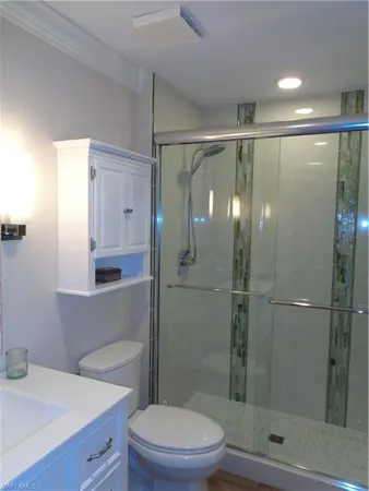 a bathroom with a shower a toilet and sink