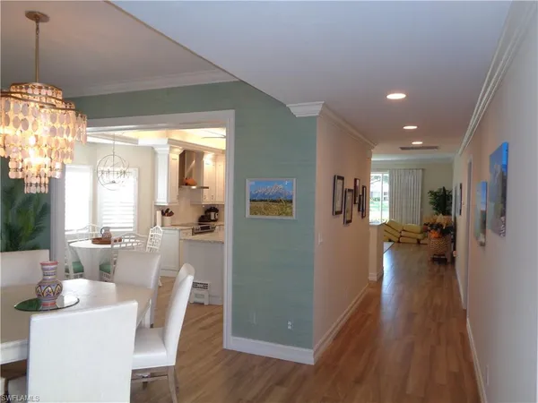 a view of a dining room and livingroom with furniture wooden floor a chandelier