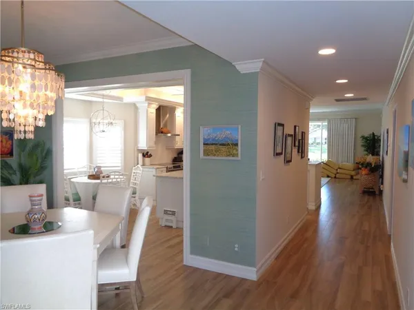 a view of a dining room with furniture a chandelier and wooden floor