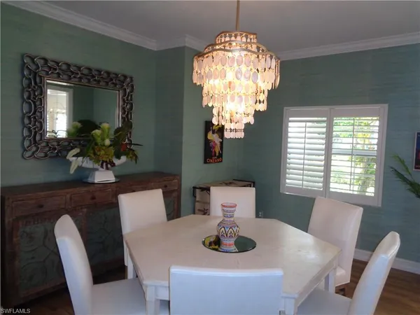a view of a dining room with furniture a chandelier and window