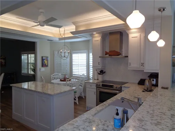 a kitchen with granite countertop a sink a stove and cabinets