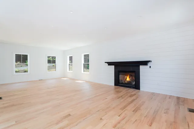 an empty room with windows and a fireplace