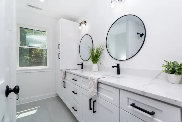 a bathroom with a double vanity sink and a mirror