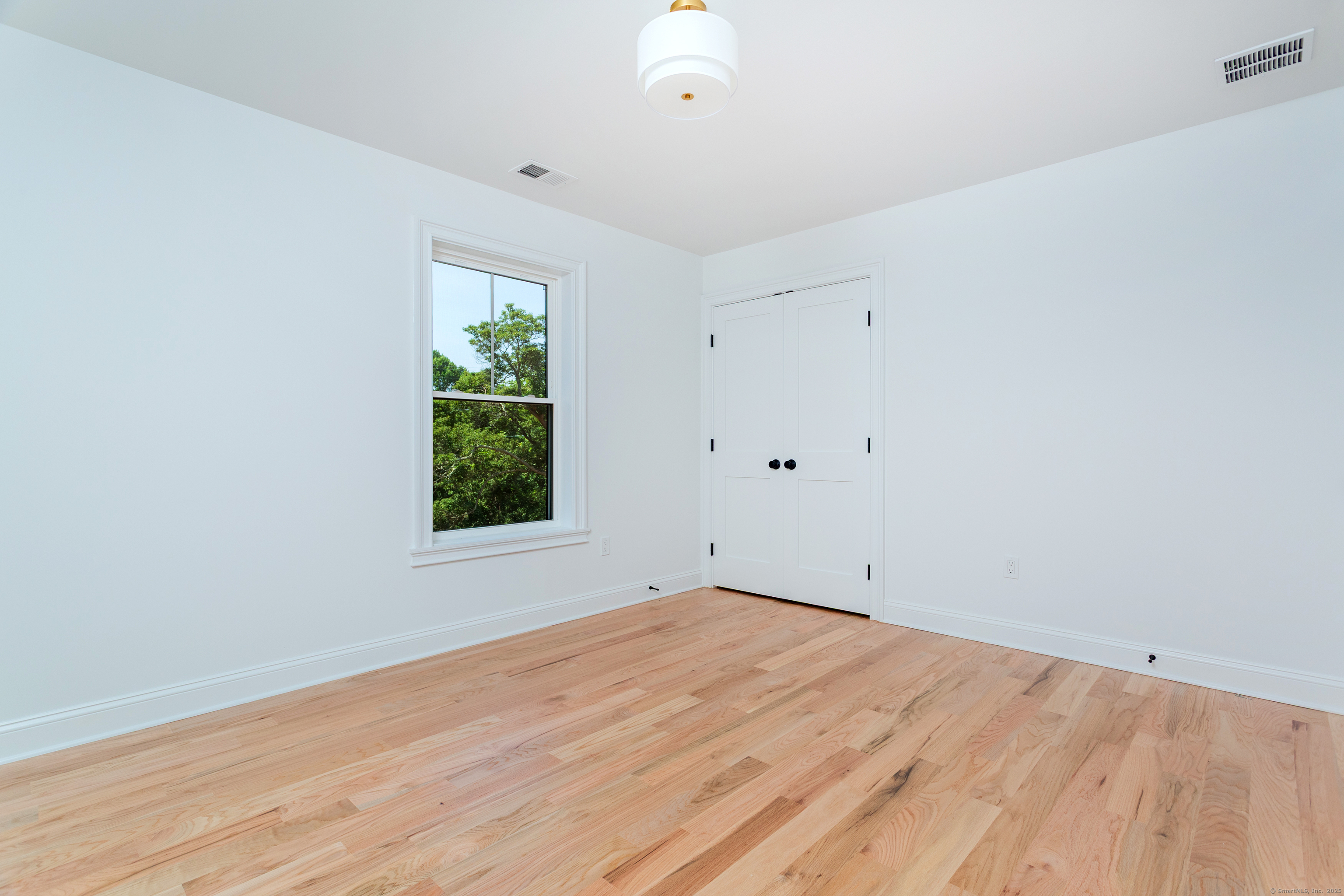 815 James Farm Road Stratford, CT 06614 - Photo 32 of 34 an empty room with wooden floor and windows