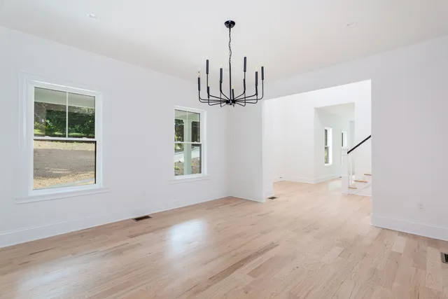 a view of empty room with wooden floor and window