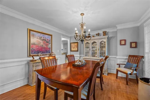 a view of a dining room with furniture a chandelier and wooden floor