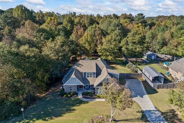 an aerial view of a house with a yard basket ball court and outdoor seating