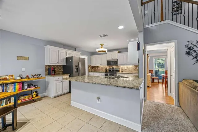 a large kitchen with kitchen island a sink stainless steel appliances and cabinets