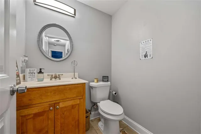 a bathroom with a toilet sink vanity and mirror