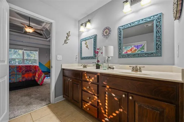 a en suite bathroom with a sink double vanity and a large mirror