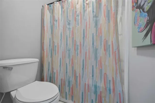 a white toilet sitting next to a shower curtain