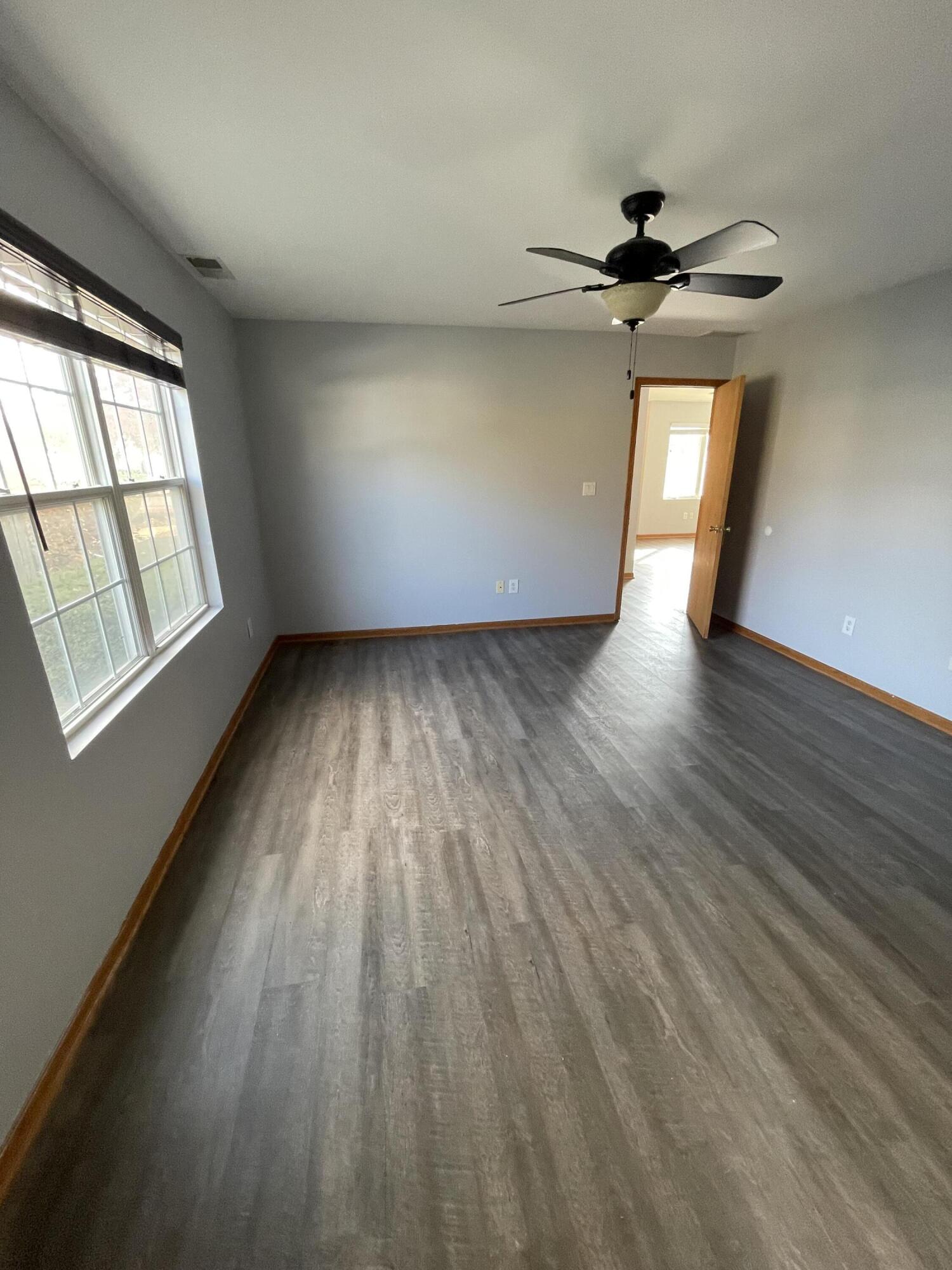 1738 Beech Drive Crown Point, IN 46307 - Photo 13 of 16 an empty room with wooden floor fan and windows