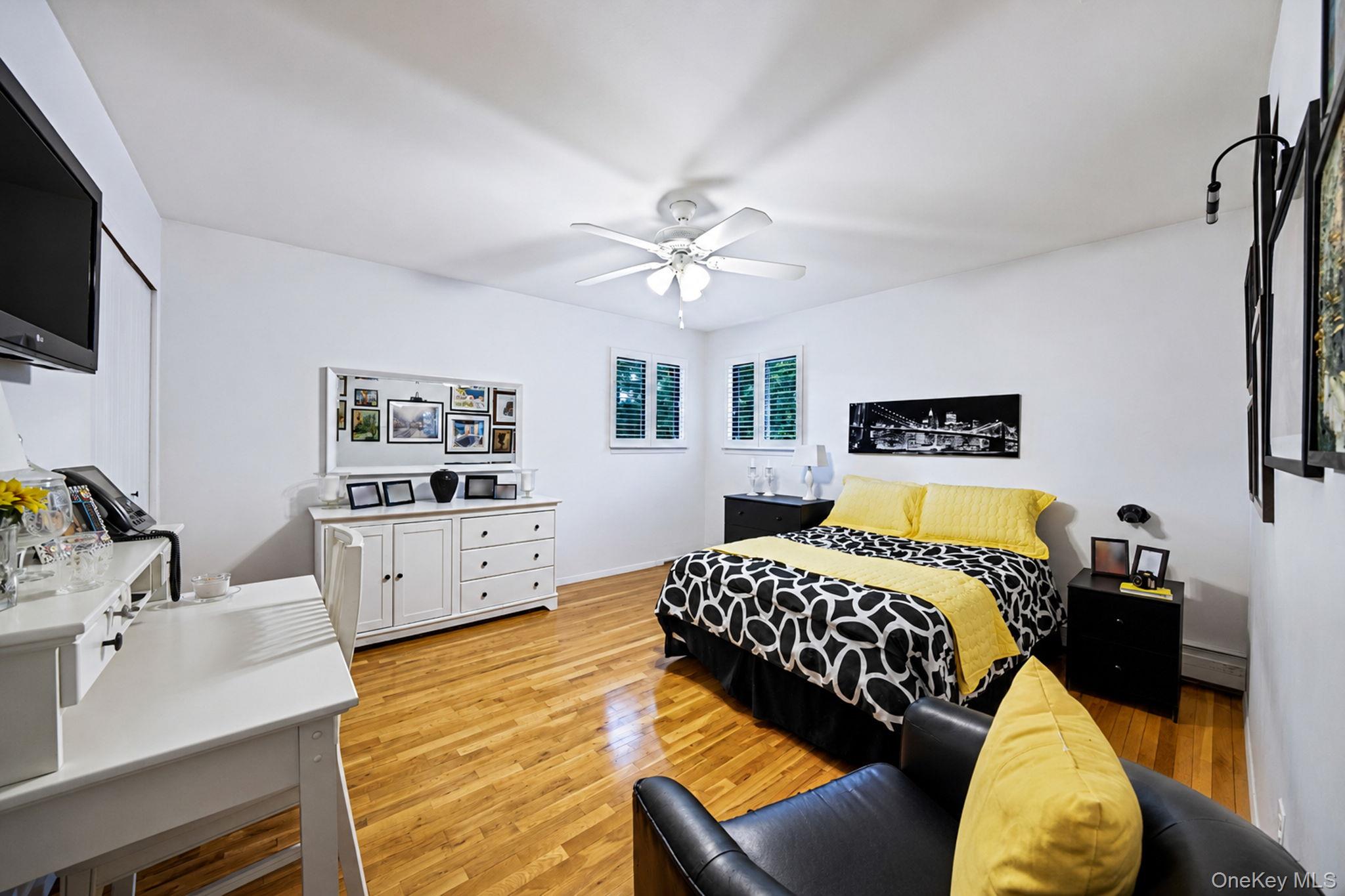 96 Fulton Boulevard Commack, NY 11725 - Photo 30 of 41 a bedroom with a bed and a flat screen tv