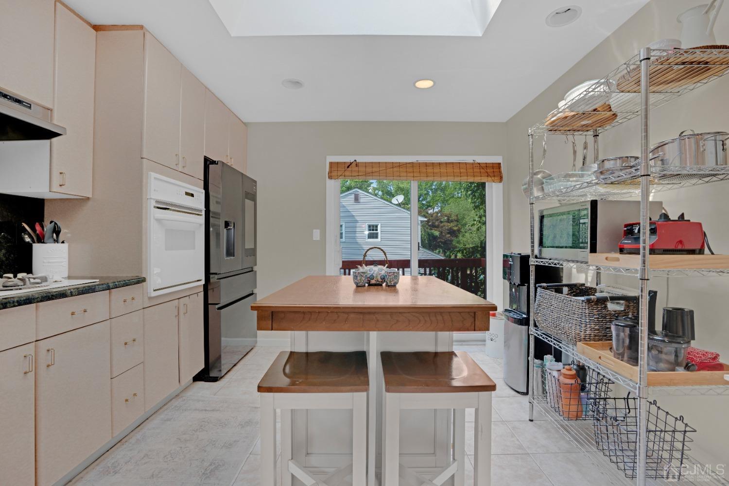 41 Laura Avenue Edison, NJ 08820 - Photo 15 of 45 a kitchen with stainless steel appliances kitchen island granite countertop a table chairs in it and wooden floors