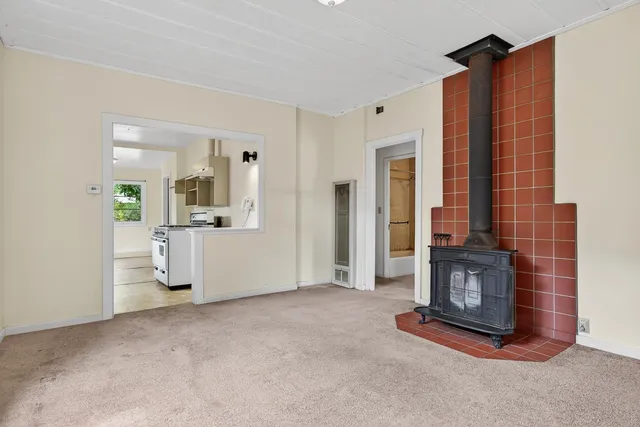 a view of an empty room with a fireplace and cabinet