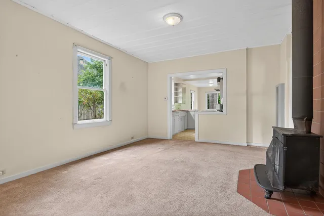 an empty room with windows and a fireplace