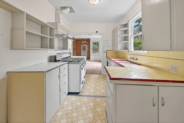 a kitchen with stainless steel appliances granite countertop a sink and a stove next to a window