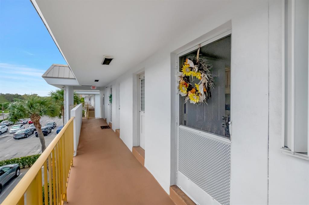 5501 Northwest 2nd Avenue, Unit 302 Boca Raton, FL 33487 - Photo 2 of 26 a view of a hallway with wooden floor and staircase