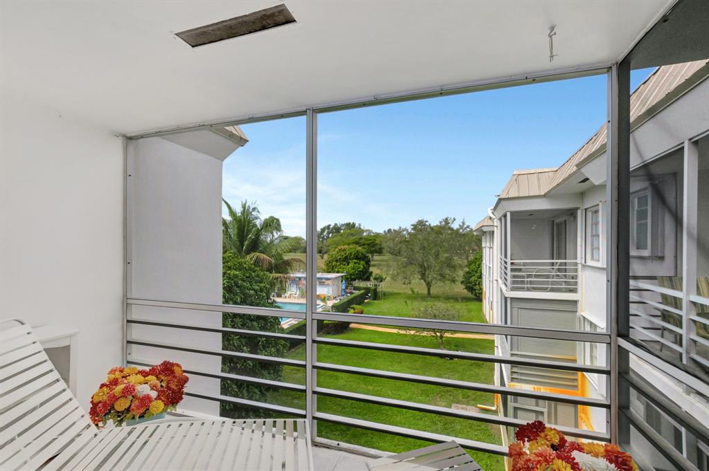 5501 Northwest 2nd Avenue, Unit 302 Boca Raton, FL 33487 - Photo 22 of 26 a view of a balcony with a floor to ceiling window and wooden fence