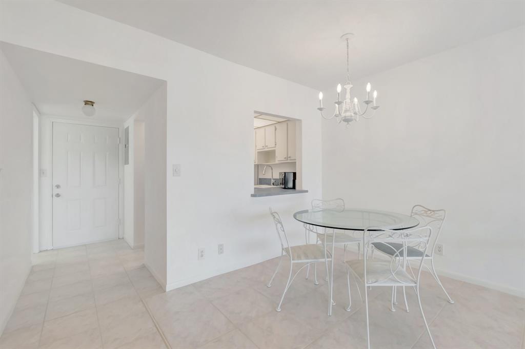 5501 Northwest 2nd Avenue, Unit 302 Boca Raton, FL 33487 - Photo 3 of 26 a view of a dining room with furniture and chandelier