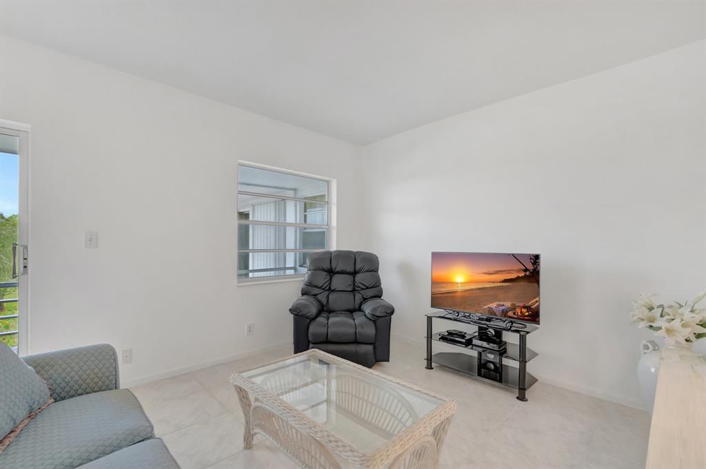 5501 Northwest 2nd Avenue, Unit 302 Boca Raton, FL 33487 - Photo 9 of 26 a living room with furniture and a flat screen tv