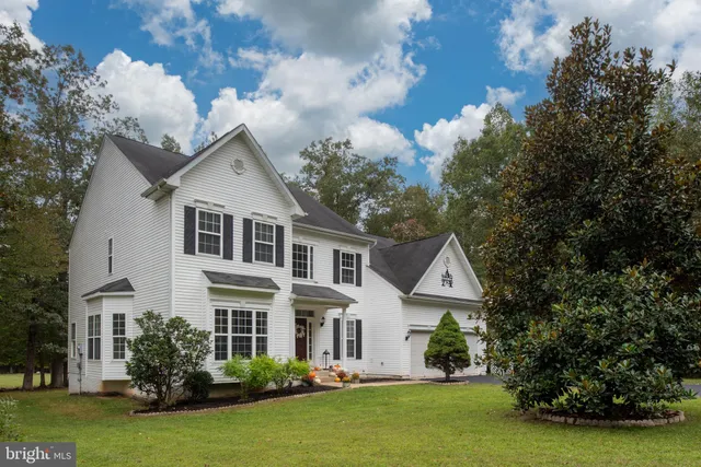a dining room with furniture a chandelier and wooden floor