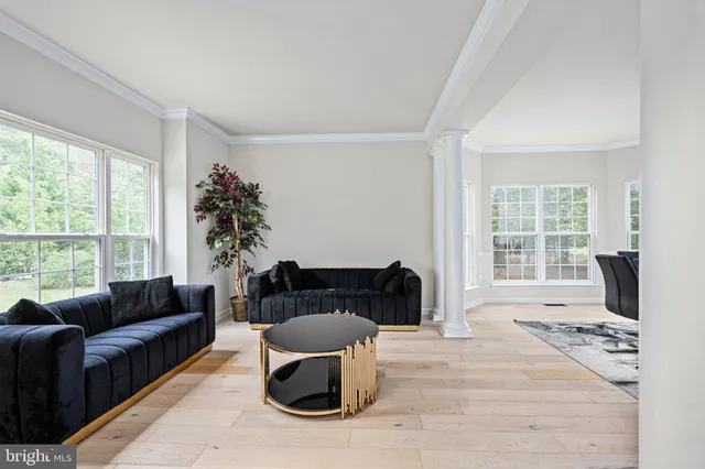 a spacious bedroom with a bed a couch and a chandelier