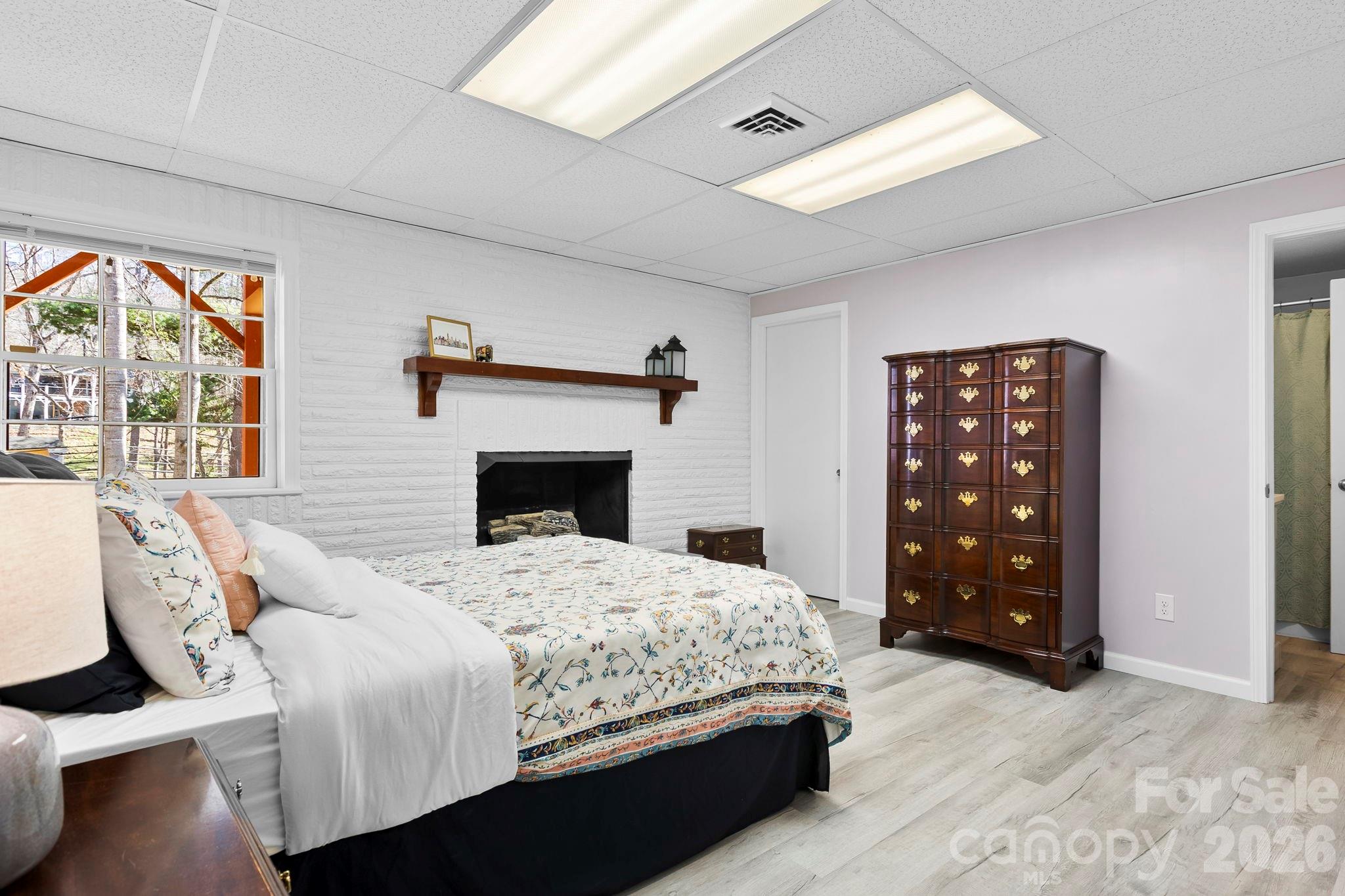 15 Blueberry Hill Road Asheville, NC 28804 - Photo 23 of 35 a bedroom with a bed a fireplace and a large window