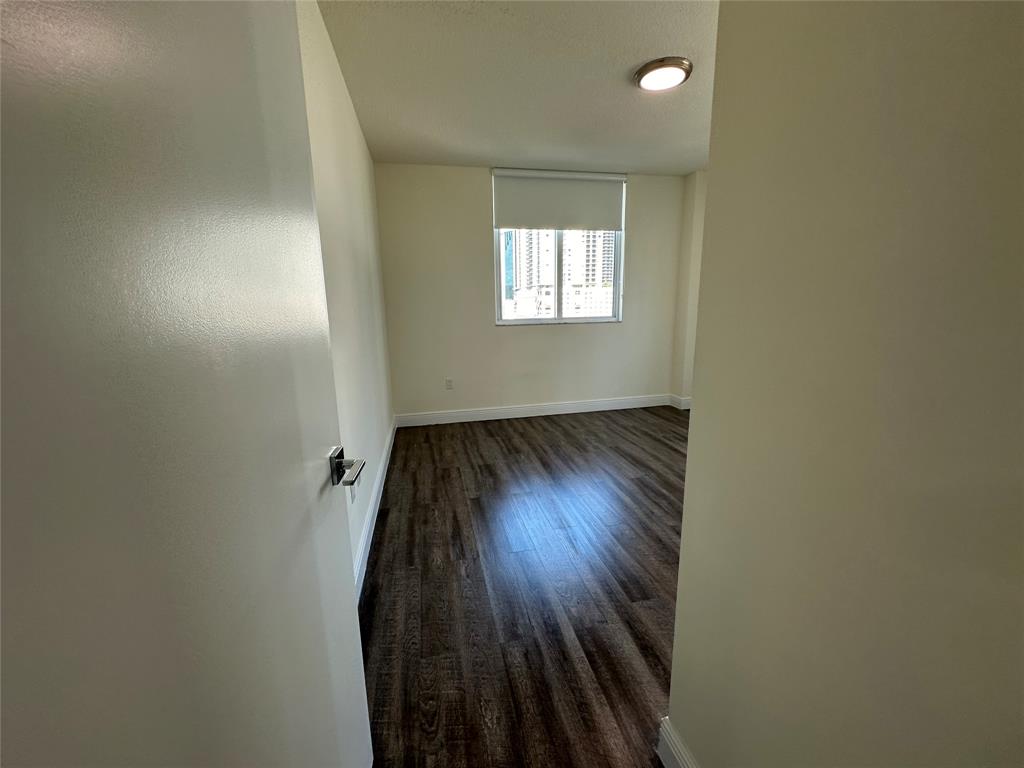 110 Southwest 12th Street, Unit 902 Miami, FL 33130 - Photo 14 of 25 an empty room with wooden floor and windows