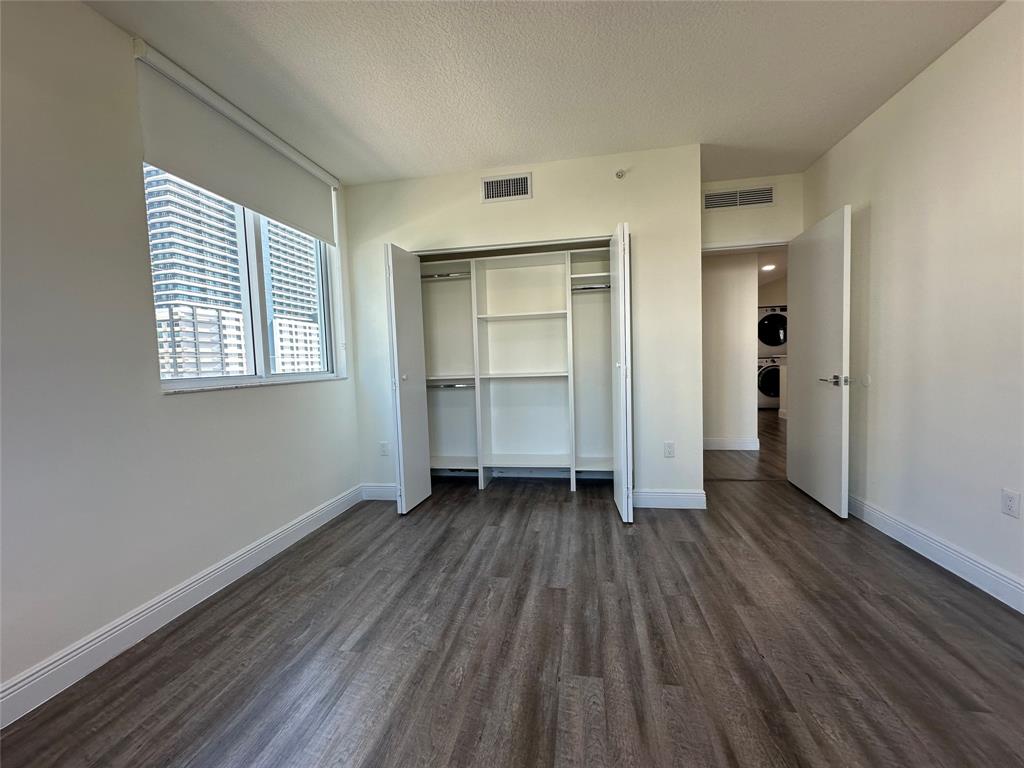 110 Southwest 12th Street, Unit 902 Miami, FL 33130 - Photo 15 of 25 an empty room with wooden floor closet and windows