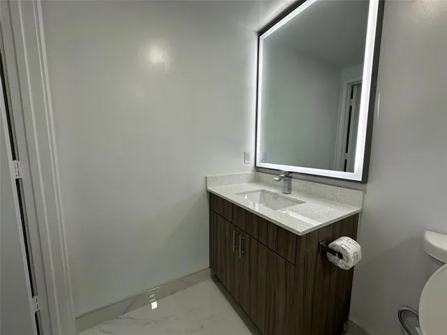 a bathroom with a sink a toilet and mirror