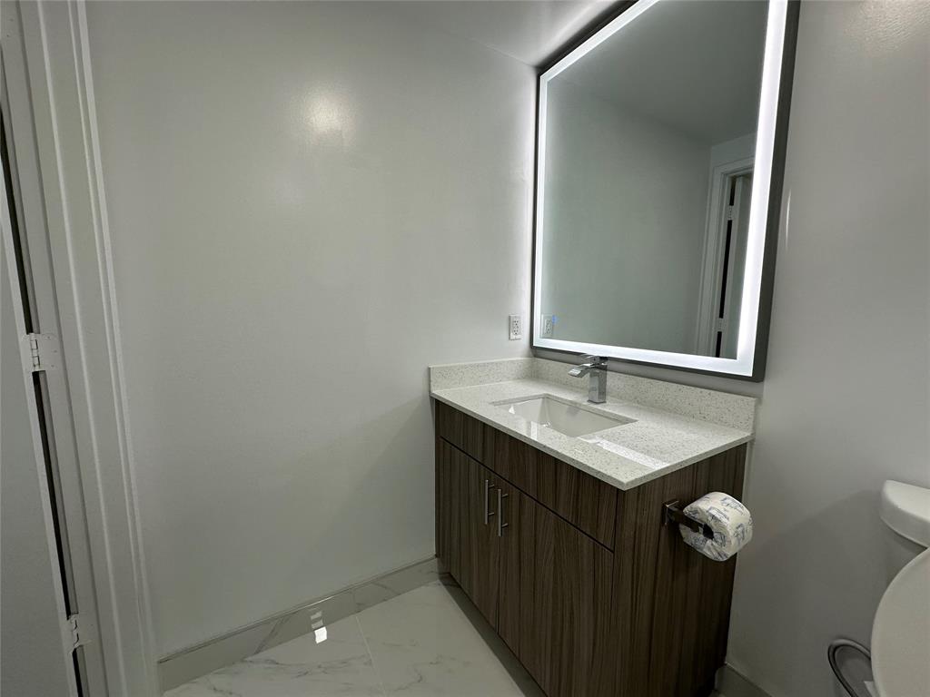 110 Southwest 12th Street, Unit 902 Miami, FL 33130 - Photo 16 of 25 a bathroom with a sink a toilet and mirror