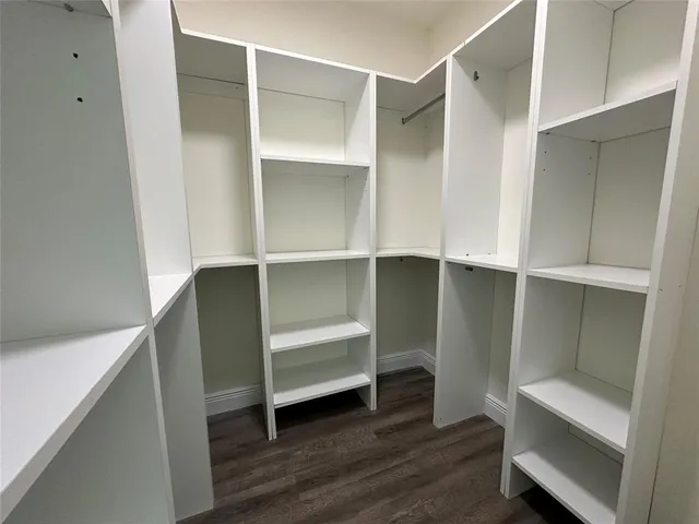 a room with walk in closet and wooden floor