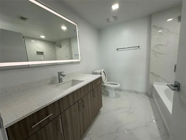 a bathroom with a sink a toilet a shower and a mirror