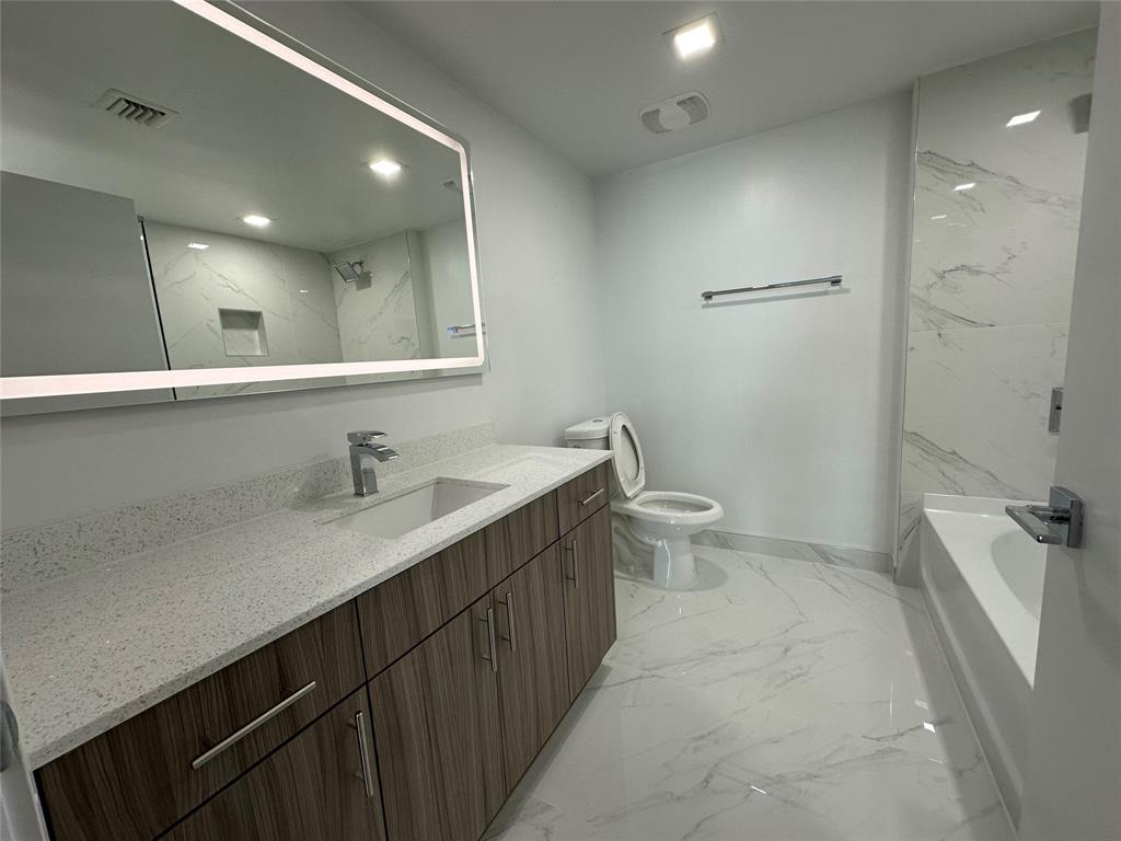 110 Southwest 12th Street, Unit 902 Miami, FL 33130 - Photo 21 of 25 a bathroom with a sink a toilet a shower and a mirror