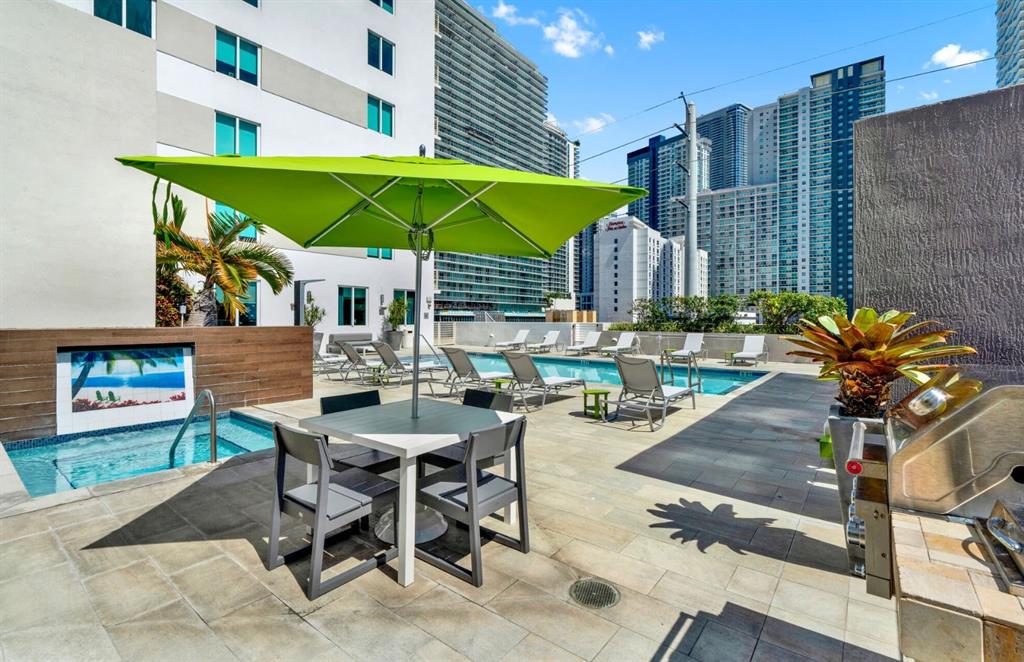 110 Southwest 12th Street, Unit 902 Miami, FL 33130 - Photo 24 of 25 a view of a patio with a table and chairs under an umbrella