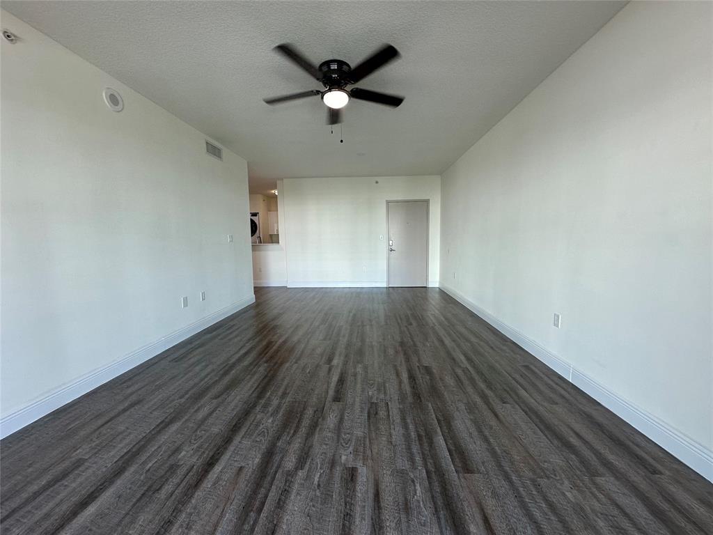 110 Southwest 12th Street, Unit 902 Miami, FL 33130 - Photo 6 of 25 an empty room with wooden floor and a ceiling fan