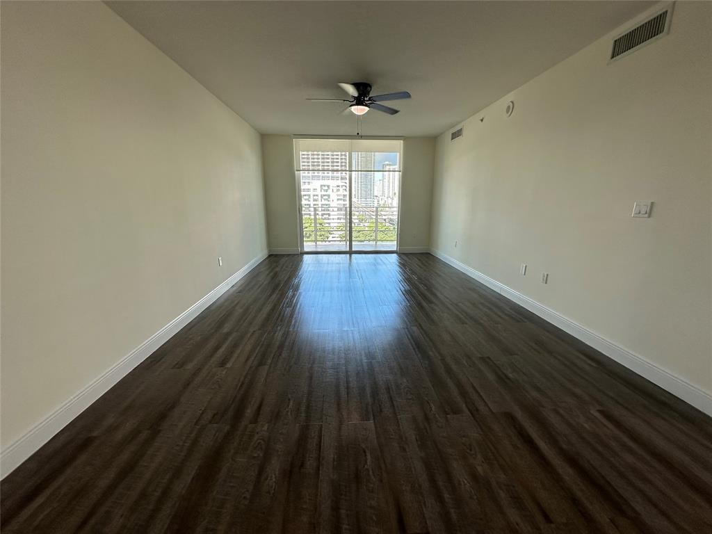 110 Southwest 12th Street, Unit 902 Miami, FL 33130 - Photo 7 of 25 a view of an empty room with wooden floor and a window